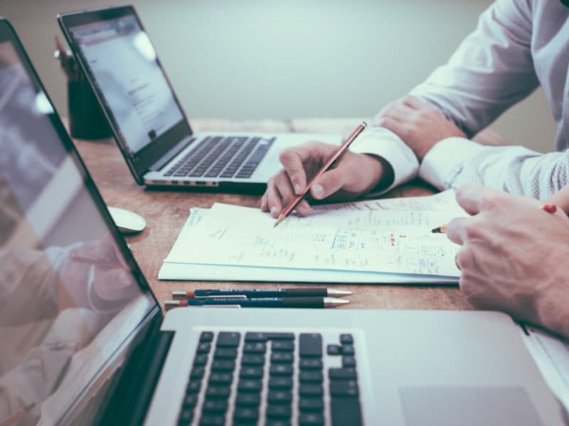 Equipe analisando gráficos e relatórios de gestão em notebooks