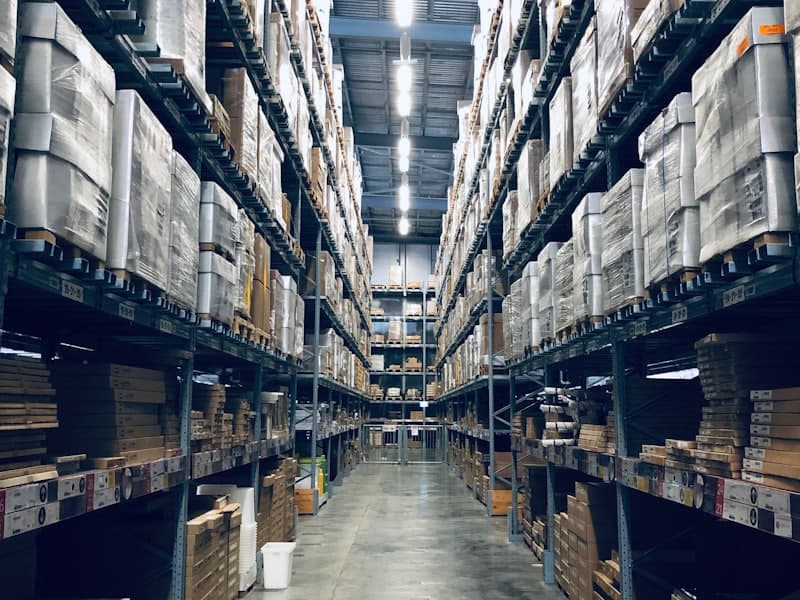 Corredor de galpão logístico com prateleiras cheias de produtos